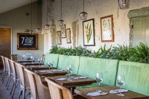 a restaurant with wooden tables and chairs and plants at The George at Backwell in Nailsea