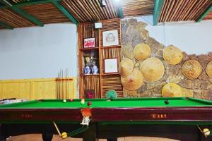 stół bilardowy w pokoju z kamienną ścianą w obiekcie 桂林时光驿青年客栈 w mieście Guilin