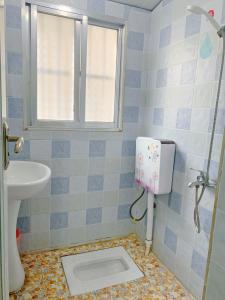 uma casa de banho com um WC, um lavatório e uma janela em 桂林时光驿青年客栈 em Guilin