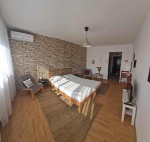 - une chambre avec un grand lit et un mur en briques dans l'établissement Sunny Place Garsoniera -posibilitate self check in, à Craiova
