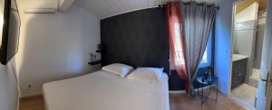 a small bedroom with a white bed and a sink at Maison de campagne in Tourrettes