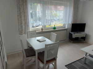 comedor con mesa, sillas y TV en Ferienwohnung Hiddesen, en Detmold