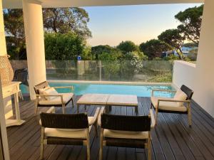 a deck with a table and chairs and a pool at Sunny Lounge Apartment in Vale do Lobo