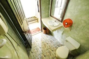 a small bathroom with a toilet and a sink at Mr Tho's Bungalows in Don Det