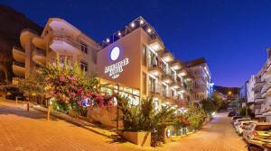 a building with a sign on the side of it at Aphrodite Hotel Kaş in Kas