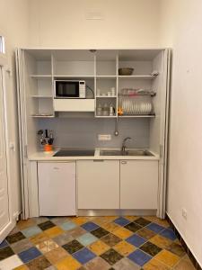 eine Küche mit einer Spüle und einer Mikrowelle in der Unterkunft B&B La Torre in Maratea