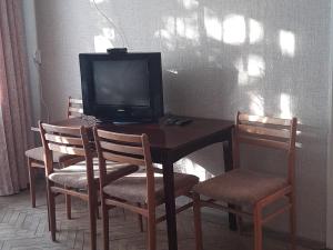 einen Fernseher auf einem Tisch mit Stühlen in der Unterkunft Эконом вариант - квартира в центре из первых рук in Tschernihiw