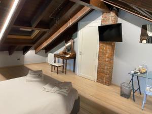 - une chambre avec un lit et une télévision murale dans l'établissement IL SALICE, à Novara