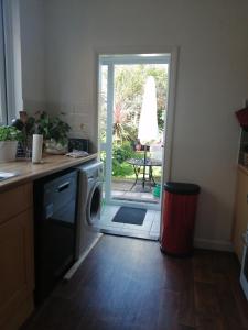 een keuken met een wasmachine en een deur naar een tuin bij Angelica place in Portsmouth