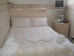 1 dormitorio con 1 cama con 2 toallas en Fern Villa Hotel - Albert Road, en Blackpool
