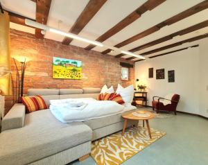 a living room with a couch and a brick wall at AVAHOME: Haus für 16, WLAN, Parkplätze, Netflix, Nespresso in Kandel