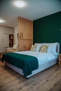 a bedroom with a large bed with a green wall at Vila K2 in Vrdnik