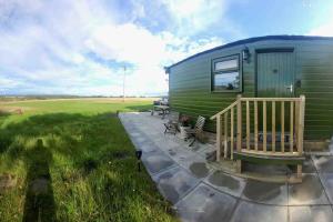 a green trailer with a porch and a patio at Runaway Northumberland in Morpeth +15 photos
