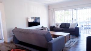 a living room with a couch and a table at The Donga House - Luxury Home near Scottburgh Beach in Scottburgh