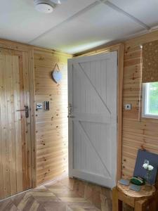 a large white door in a room with wooden walls at Runaway Northumberland in Morpeth