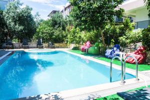 a large swimming pool with chairs next to a building at Ale Park Hotel Apartments in Antalya