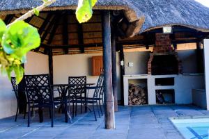 a house with chairs and a thatch roof at The Donga House - Luxury Home near Scottburgh Beach in Scottburgh