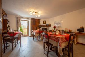 uma sala de jantar com mesas e cadeiras e uma lareira em Eco Dimora Baltea - Affittacamere al Verde villaggio di Rumiod em Saint-Pierre