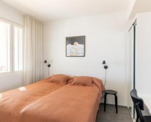 a bedroom with a bed with an orange blanket at Polar Charm huoneistot H ja J in Ylläsjärvi +13 photos