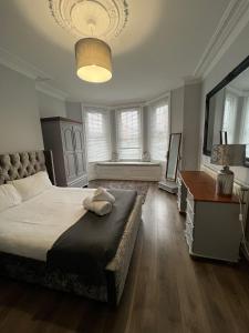 1 dormitorio con 1 cama, escritorio y ventanas en Alexander Apartments South Shields 2, en South Shields