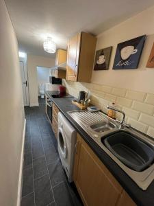 uma cozinha com um lavatório e uma máquina de lavar roupa em Alexander Apartments South Shields 2 em South Shields