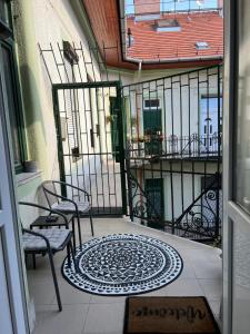 a balcony with two chairs and a rug on the floor at Allomas Apartman in Budapest
