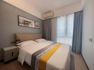 um quarto com uma cama grande e uma janela em Canopy Executive Apartments - Liuxian Cave Headquarters em Shenzhen