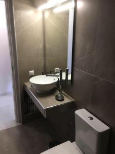 a bathroom with a sink and a toilet and a mirror at DION APARTMENTS in Paleros