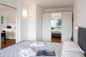 a bedroom with a bed with towels and a mirror at Ruvigliana Amazing View - Happy Rentals in Lugano
