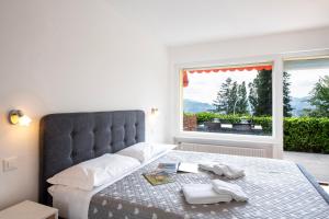 a bedroom with a large bed and a window at Ruvigliana Amazing View - Happy Rentals in Lugano