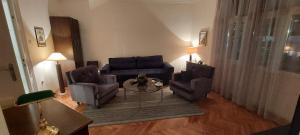 een woonkamer met een bank, twee stoelen en een tafel bij Bohemian in Belgrado