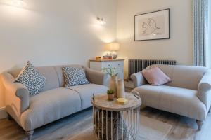 a living room with two couches and a table at Wallhope Retreat in Chepstow