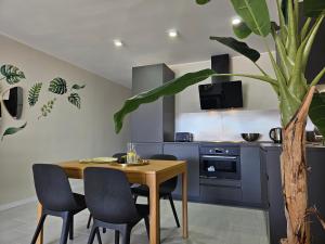 une cuisine avec une table et des chaises en bois ainsi qu'une plante dans l'établissement PaulMarie Apartment Playa La Arena, à Puerto de Santiago