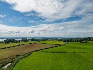 an aerial view of a green field with trees and clouds at Wallhope Retreat in Chepstow