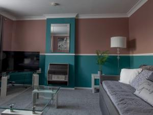 een woonkamer met een bank en een tv bij Pass the Keys Flat close to amenities in Scunthorpe