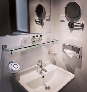 a bathroom with a sink and a mirror at ss Rotterdam Hotel en Restaurants in Rotterdam