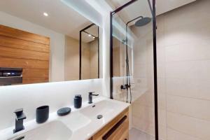 uma casa de banho com um lavatório e um chuveiro em Appartement neuf à Mottaret / A12 em Les Allues