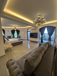un grand salon avec un canapé et une télévision dans l'établissement Ami Residence Bucharest Airport,Therme&FREE PARKING Otopeni, à Otopeni