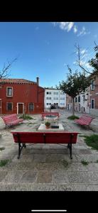 a group of red benches sitting in a courtyard at Appartement GIUDECCA in Venice