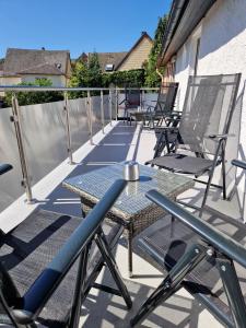 d'une terrasse avec des chaises et une table sur un balcon. dans l'établissement Föller´s Gästehaus, à Neu-Anspach