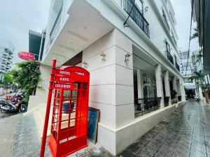 a red telephone booth in front of a building at Amy Hotel Hue in Hue