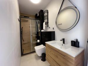 a bathroom with a sink and a mirror at URBAN APARTMENTS PREMIUM, Opolska 10 No 77A, Free Garage, Self Check-in in Katowice +19 photos