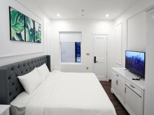 ein weißes Schlafzimmer mit einem Bett und einem Flachbild-TV in der Unterkunft Amy Hotel & Apart' Hue in Hue