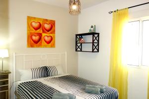 a bedroom with a bed with a painting of hearts at Casa Limón - Ferienhaus - Pool - Klimaanlage - W-Lan in Chiclana de la Frontera +22 photos