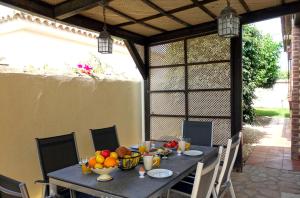a table with bowls of fruit on top of it at Casa Limón - Ferienhaus - Pool - Klimaanlage - W-Lan in Chiclana de la Frontera