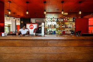 a man standing behind the bar of a restaurant at Lloret Vibe Affiliated by FERGUS in Lloret de Mar