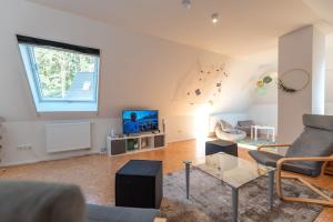 a living room with a couch and a tv at Ferienwohnung Schwanensee in Kölpinsee