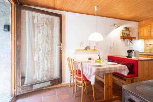 une cuisine avec une table et des chaises ainsi qu'une fenêtre dans l'établissement Rustico Stock - Happy Rentals, à Lugano