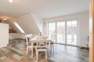 a kitchen and dining room with a white table and chairs at Ferienwohnung Schwanensee in Kolpinsee