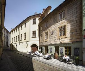 una calle con edificios, mesas y sillas en una calle en Black Star Suites en Praga
